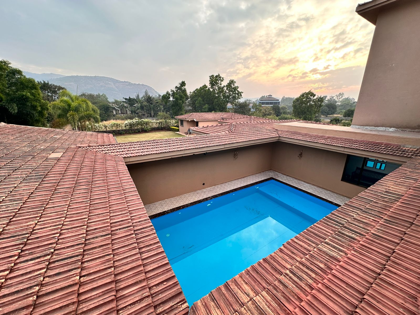 Pool contractor — Hilltop villa swimming pool with terracotta roof and mountain view